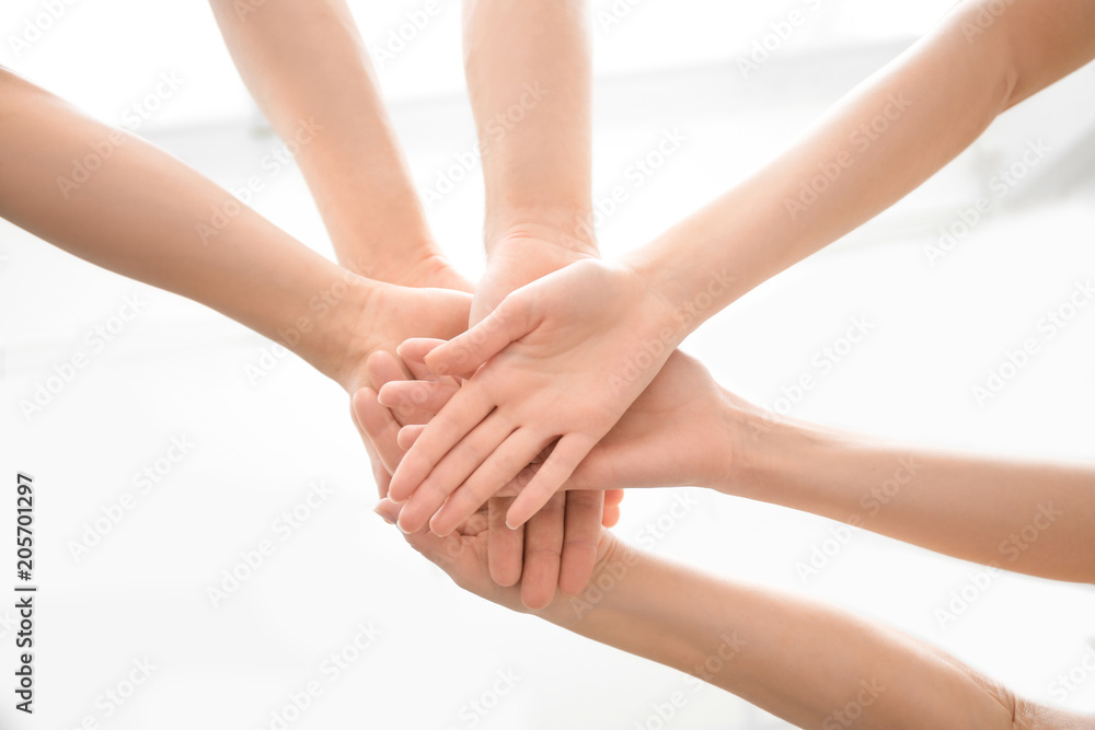 People putting hands together on light background, closeup. Unity concept People putting hands together on light background, closeup. Unity concept
