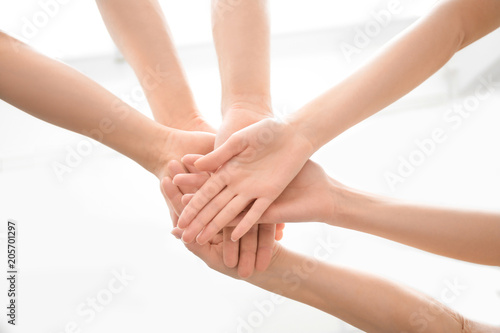 People putting hands together on light background, closeup. Unity concept