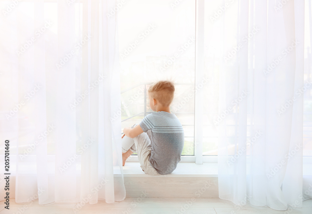Little boy sitting near window. Autism concept Little boy sitting near window. Autism concept
