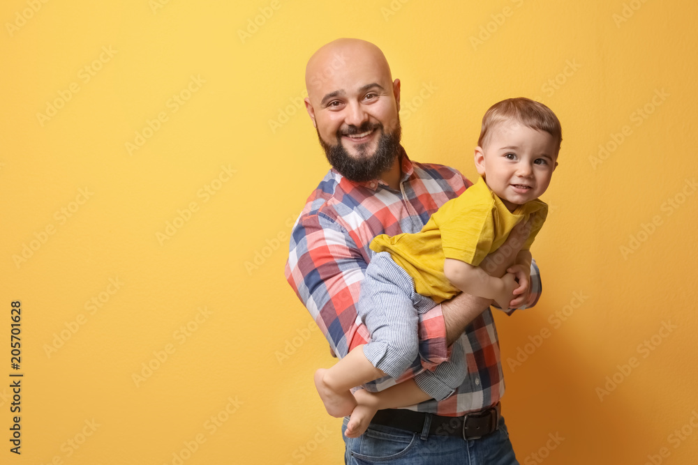 Portrait of dad and his little son on color background Portrait of dad and his little son on color background