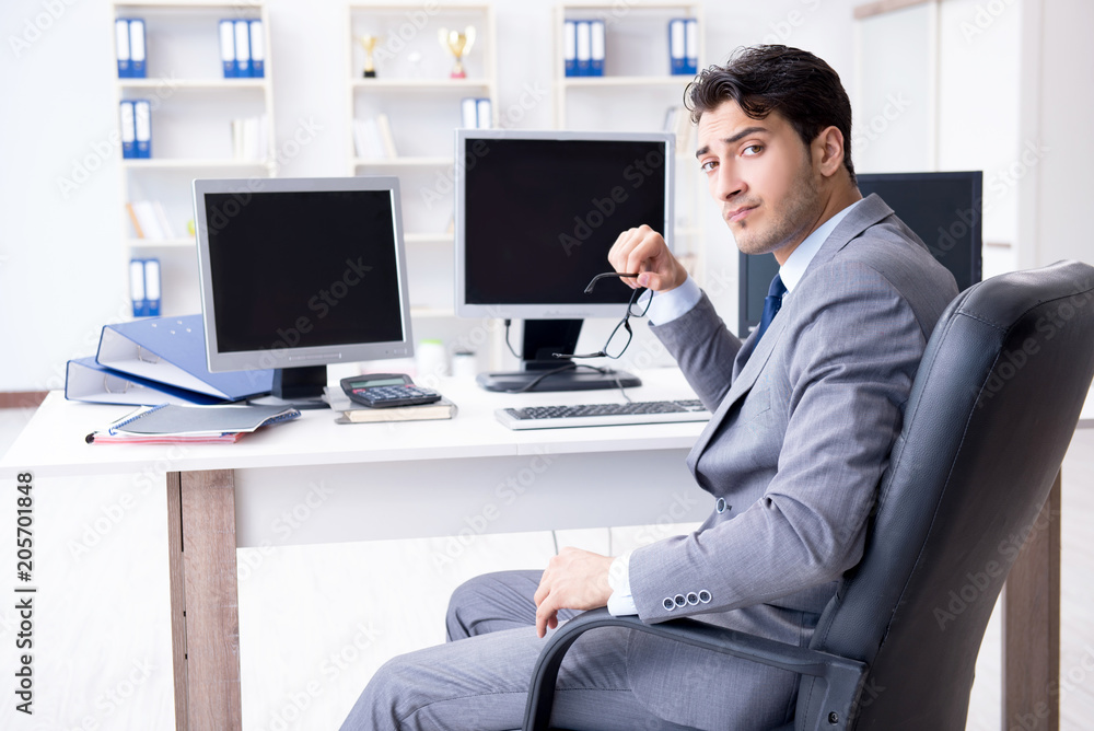 Businessman sitting in front of many screens Businessman sitting in front of many screens
