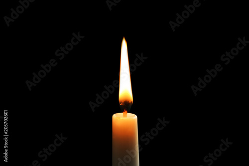 Wax candle burning on black background