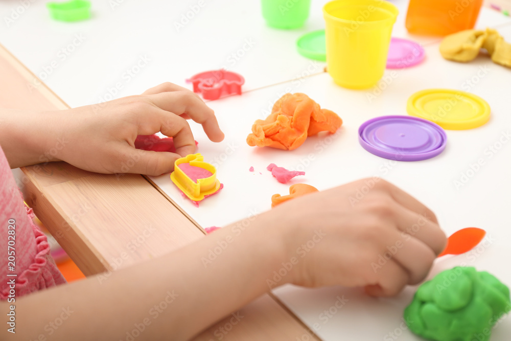 Cute little girl using play dough at table, closeup Cute little girl using play dough at table, closeup