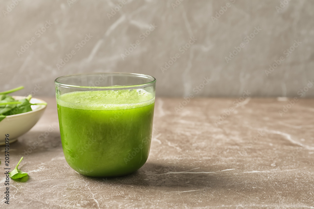 Glass with delicious detox juice and spinach on table Glass with delicious detox juice and spinach on table