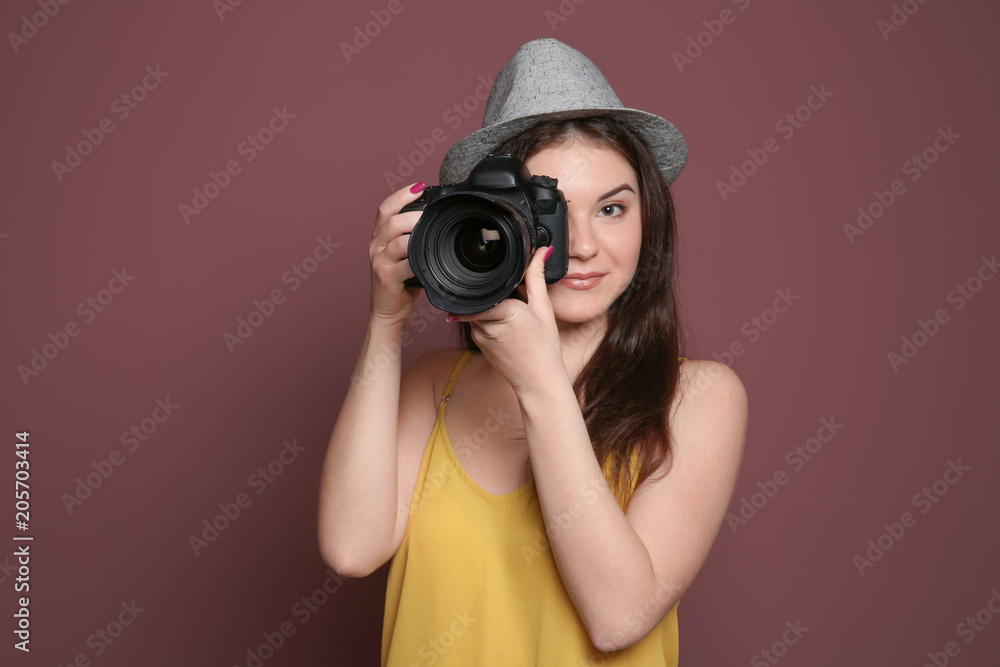 Female photographer with professional camera on color background Female photographer with professional camera on color background