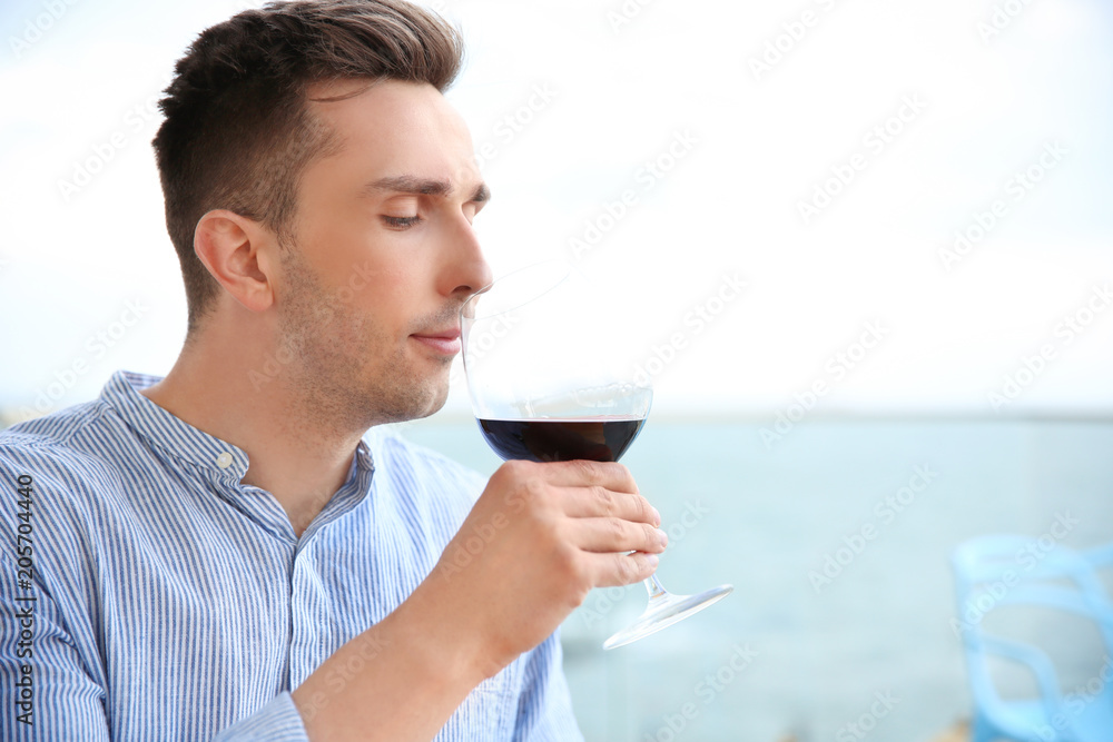 Young man with glass of red wine outdoors Young man with glass of red wine outdoors