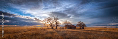 Canvas Print Old farmhouse at sunset in the countryside
