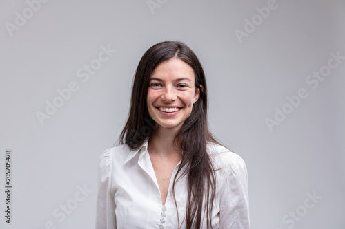 Young long-haired smiling woman in white shirt