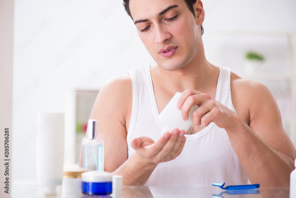 Young handsome man shaving early in the morning at home Young handsome man shaving early in the morning at home