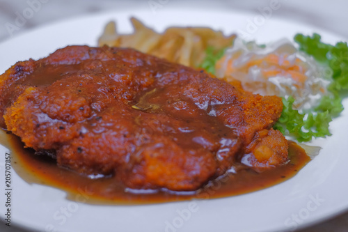 Chicken chop with vegetable and black pepper sauce in plate over dining table