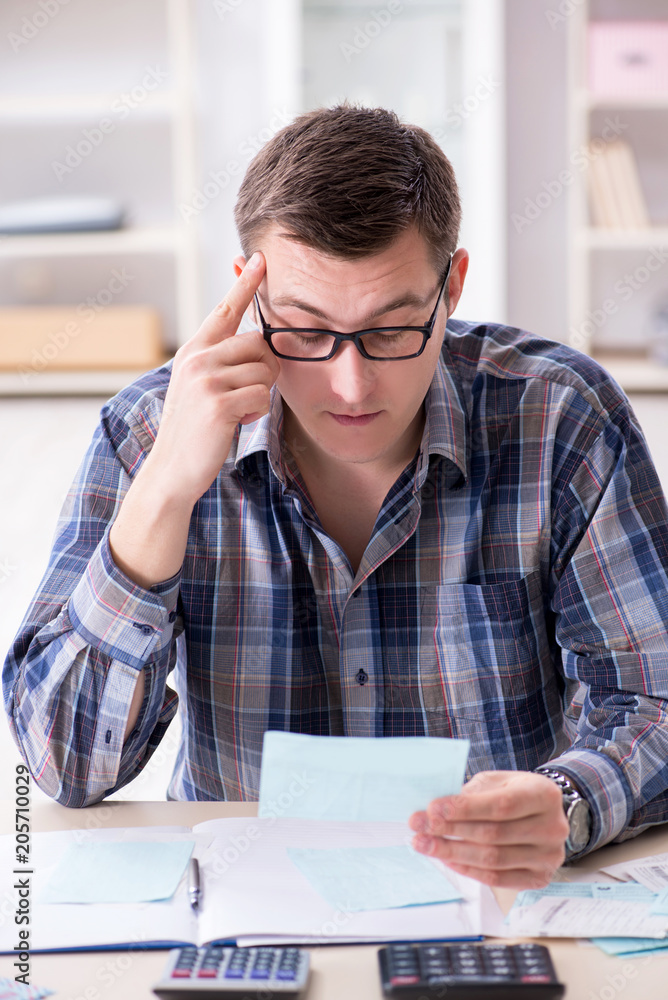 Young man frustrated at his house and tax bills Young man frustrated at his house and tax bills