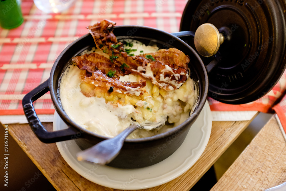 Delicious traditional alsacian pasta plate Spatzle, with bacon and served on a black pan Delicious traditional alsacian pasta plate Spatzle, with bacon and served on a black pan