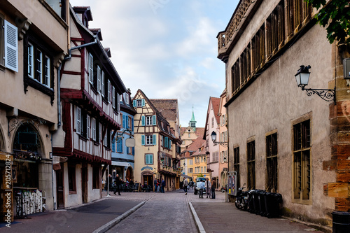 Gorgeous cobbled street in Colmar, Alsace, with the Colmar Cathedral in the background photo