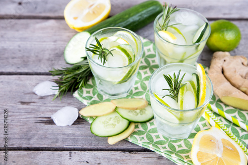 Homemade Lemonade with Lime  Rosemary  Ginger  Cucumber and Ice on a Wooden Background