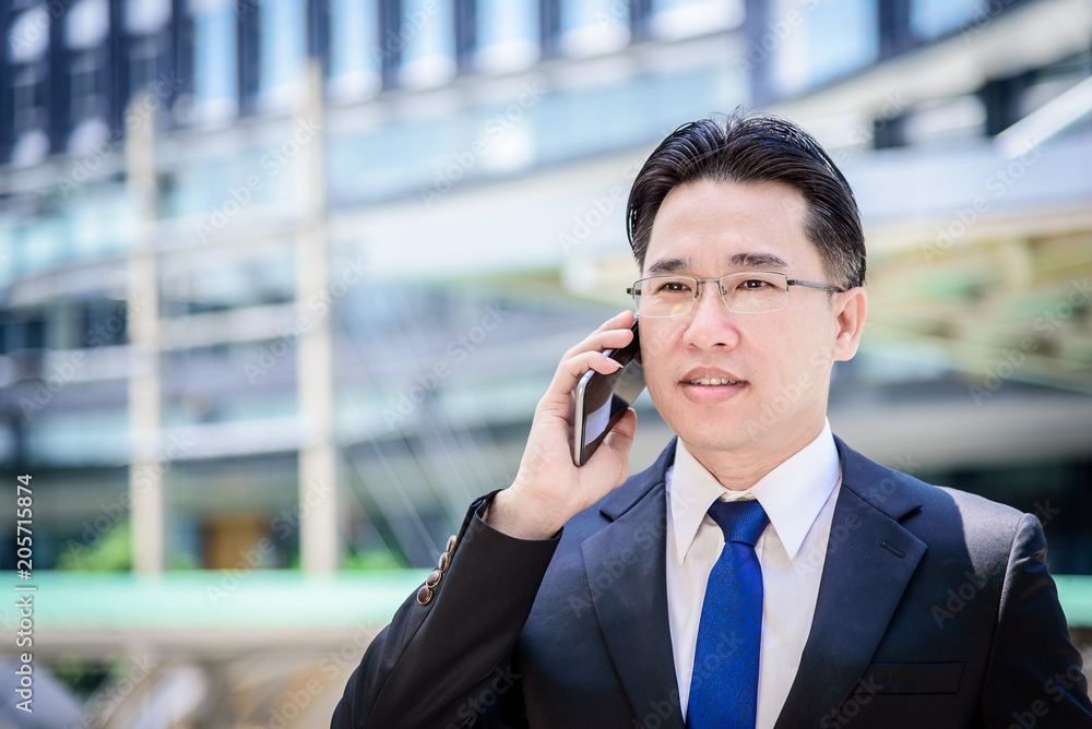 The asian businessman has working on mobile with happy. The asian businessman has working on mobile with happy.