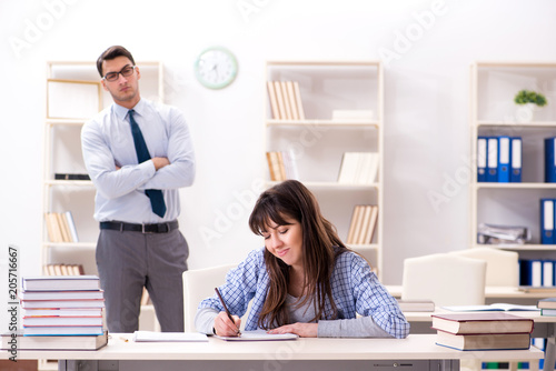 Male lecturer giving lecture to female student