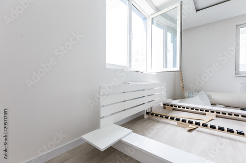 Assembling wooden bed in room