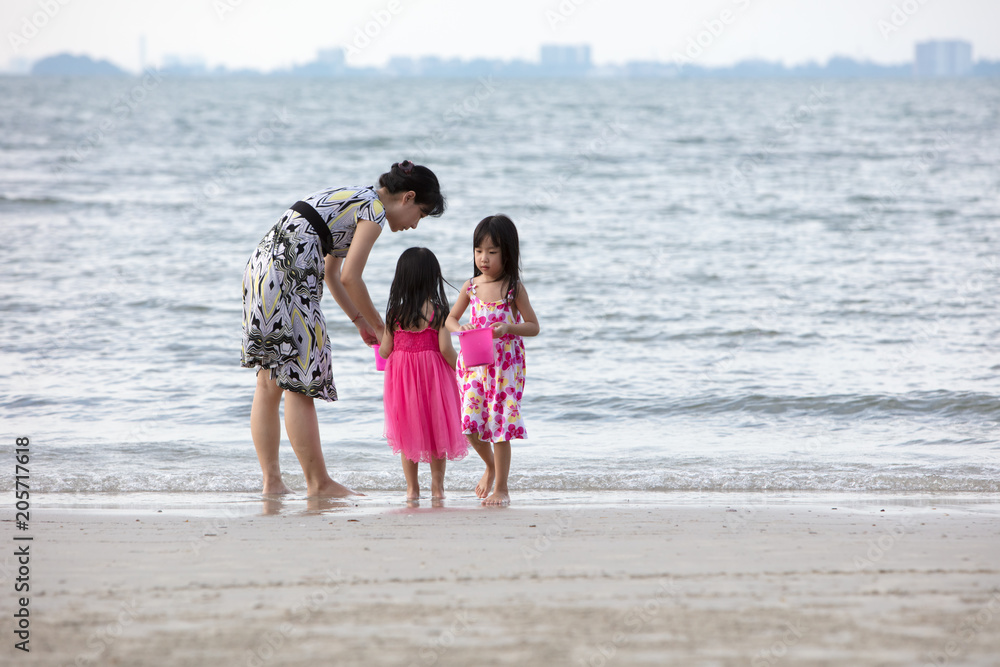 Asian Chinese mum and daughters playing sand together Asian Chinese mum and daughters playing sand together