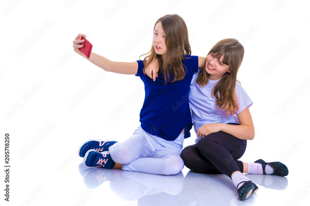 Two girls make a self-portrait on a smartphone.