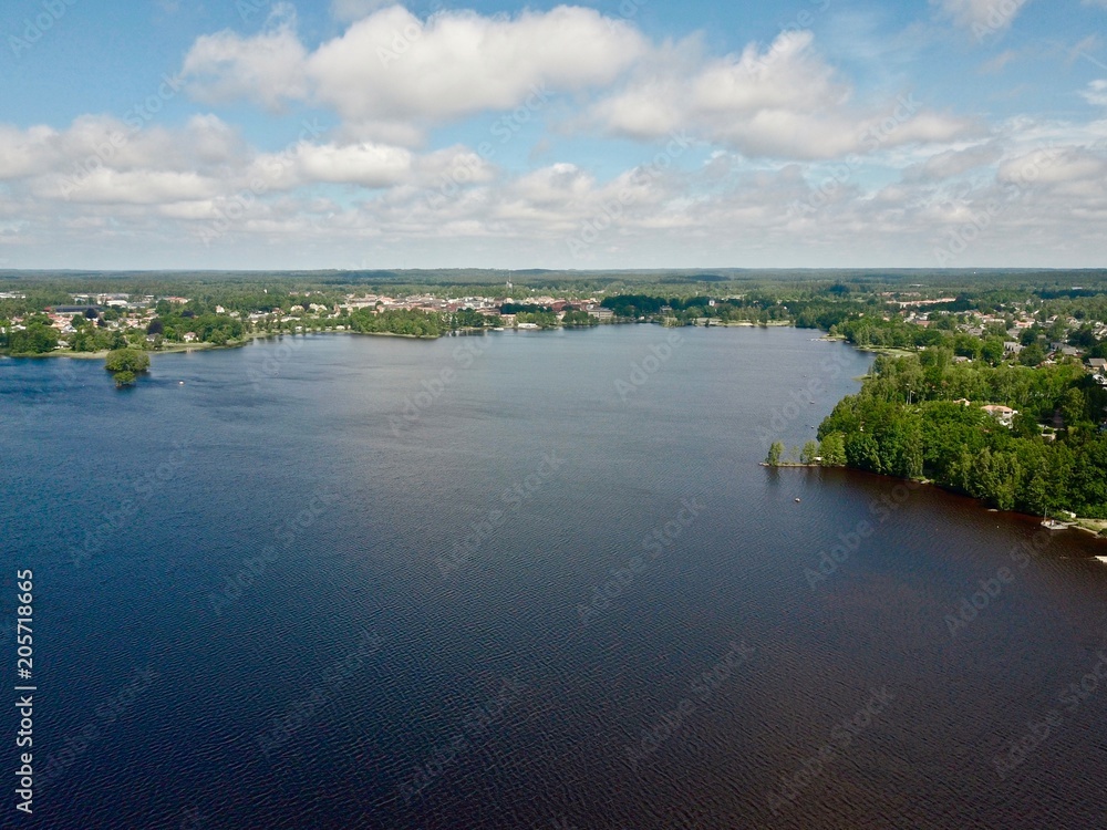 Drone view of a big lake in Sweden with a city on the background, Summer in Sweden