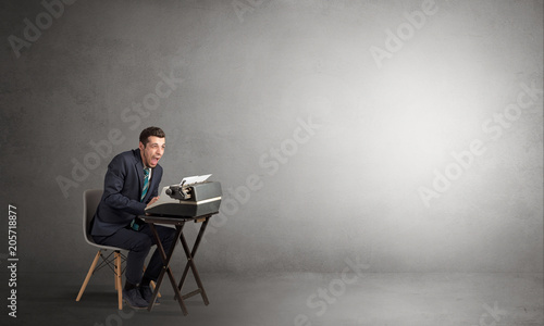Man working hard on a typewriter in an empty space 