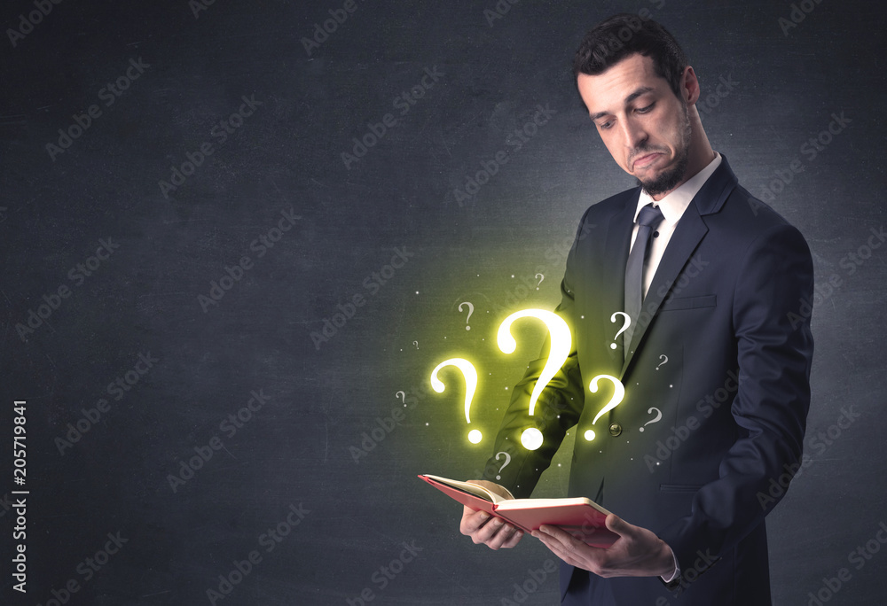 Businessman holding a book with question mark symbol. Businessman holding a book with question mark symbol.