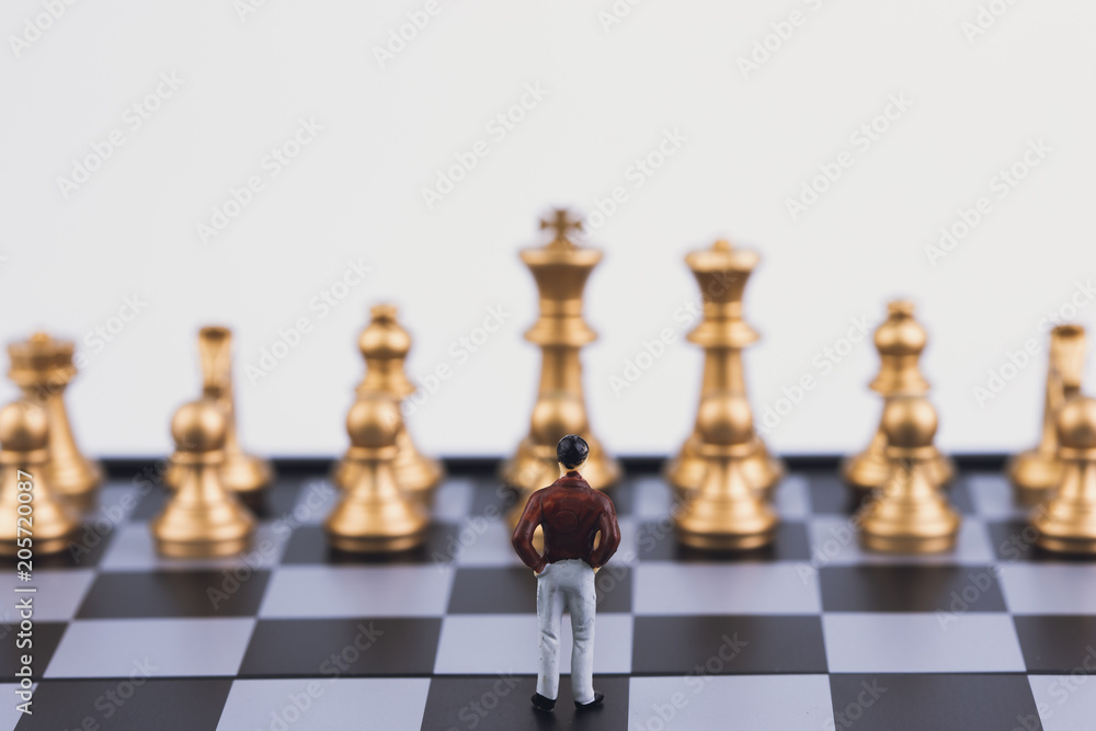 Plan leading strategy of successful business leader concept. Miniature people small figure businessman standing alone on chess board game. With copy space. Teamwork, Management, Leadership. Plan leading strategy of successful business leader concept. Miniature people small figure businessman standing alone on chess board game. With copy space. Teamwork, Management, Leadership.