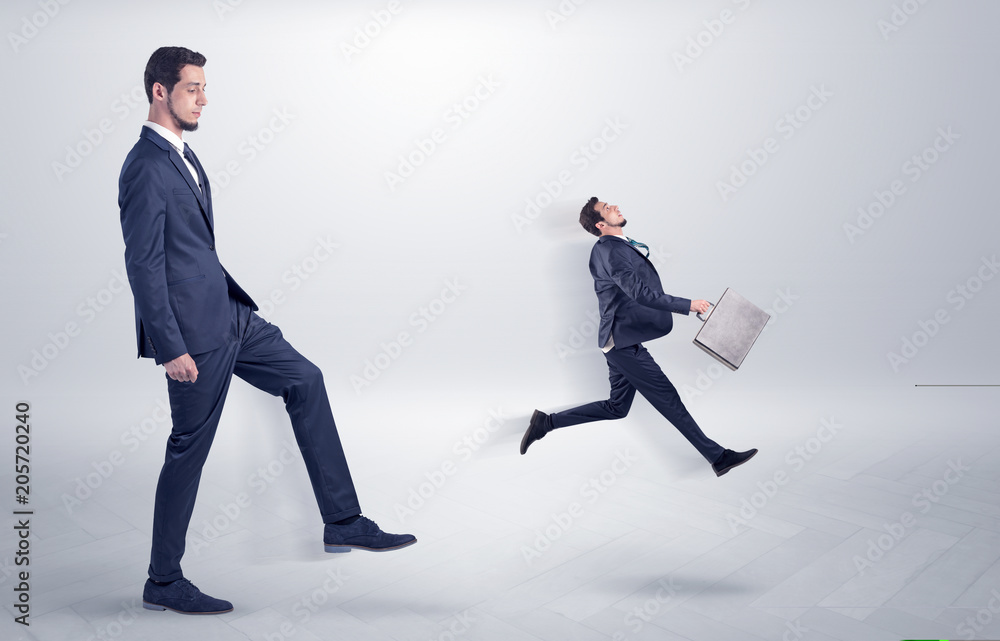 Fototapeta premium Small young man fired by his bos from his workplace with suitcase on his hand 
