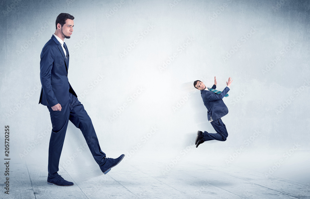 Big businessman kicking small businessman who is flying away with his briefcase on his hand
Big businessman kicking small businessman who is flying away with his briefcase on his hand