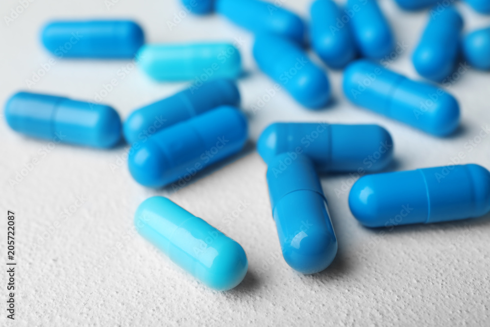 Many blue pills on light surface, closeup Many blue pills on light surface, closeup