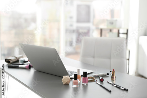 Makeup products for woman and laptop on table © New Africa