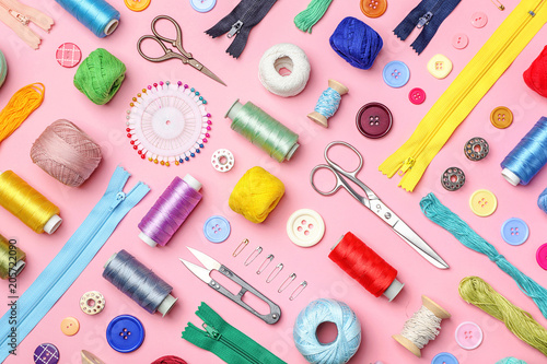 Composition with threads and sewing accessories on color background, flat lay photo
