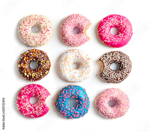 Delicious doughnuts with sprinkles on light background, top view