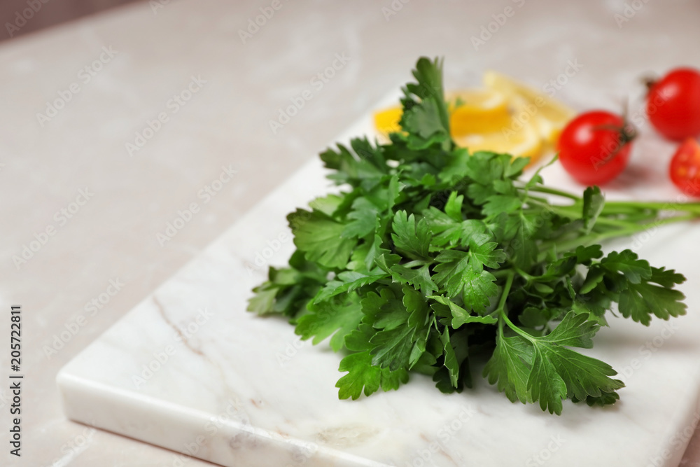 Stone board with fresh green parsley on table, closeup Stone board with fresh green parsley on table, closeup