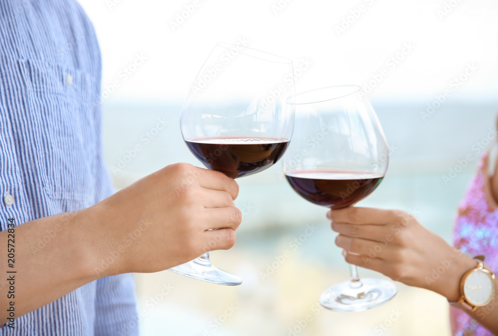 Young romantic couple with glasses of red wine outdoors