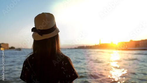 Romantic young lady enjoying Venice sunset alone on seashore, tourism as hobby