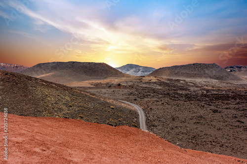 A road crossing the Timanfaya National Park at sunset. Lanzarote, Canary Islands, Spain. photo