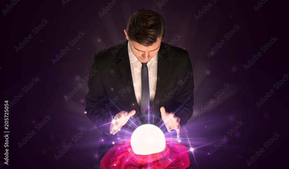 Fototapeta premium Young businessman sitting with crystal ball in action