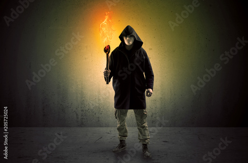 Ugly scary man with burning flambeau walking in an empty space