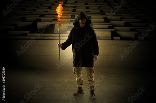 Photos Ugly, aberrant man coming out from the labyrinth with burning flambeau on his ha