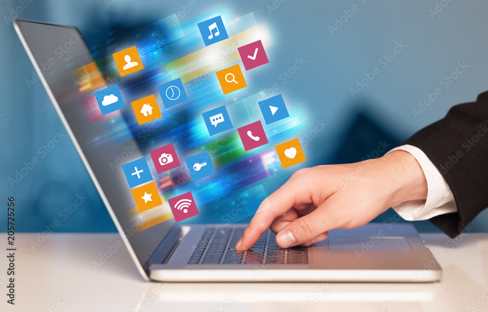 Hand using laptop with colorful fast moving application icons and symbols concept
Hand using laptop with colorful fast moving application icons and symbols concept