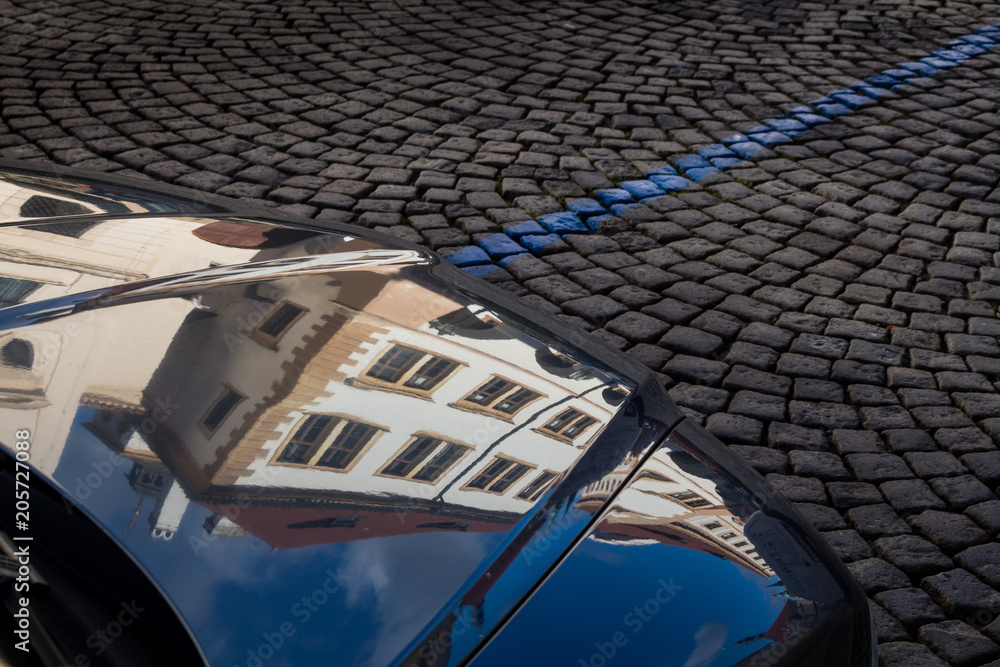 Obraz premium Detail of a car with reflection of the historical houses. Prague, Czech republic