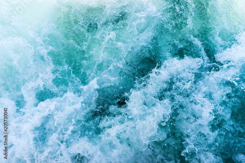 Fototapeta Naklejka Na Ścianę i Meble -  Turquoise blue wavy seawater with foam and waves, background texture.