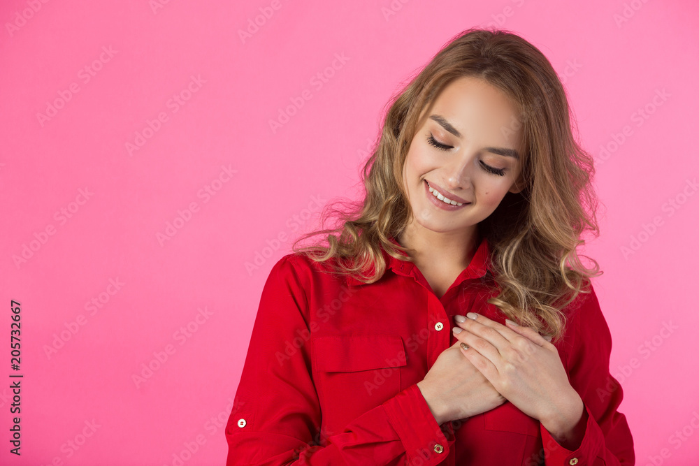 young joyful beautiful girl in red attire on a pink background young joyful beautiful girl in red attire on a pink background