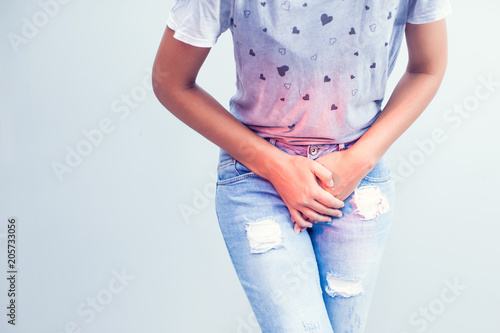 Young sick woman with hands holding pressing her crotch lower abdomen. Medical or gynecological problems, healthcare concept photo