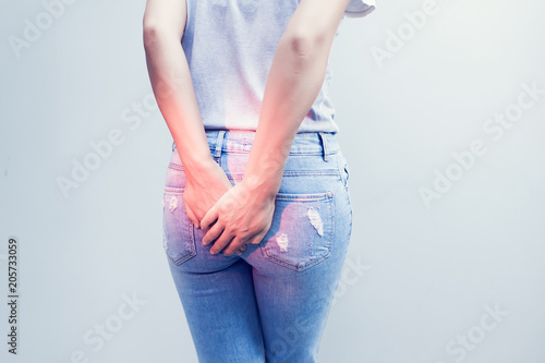Woman hand holding her bottom because having Abdominal pain and Hemorrhoids, Health care concept. photo