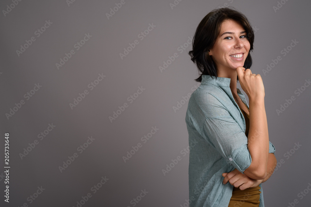 Young beautiful woman against gray background Young beautiful woman against gray background