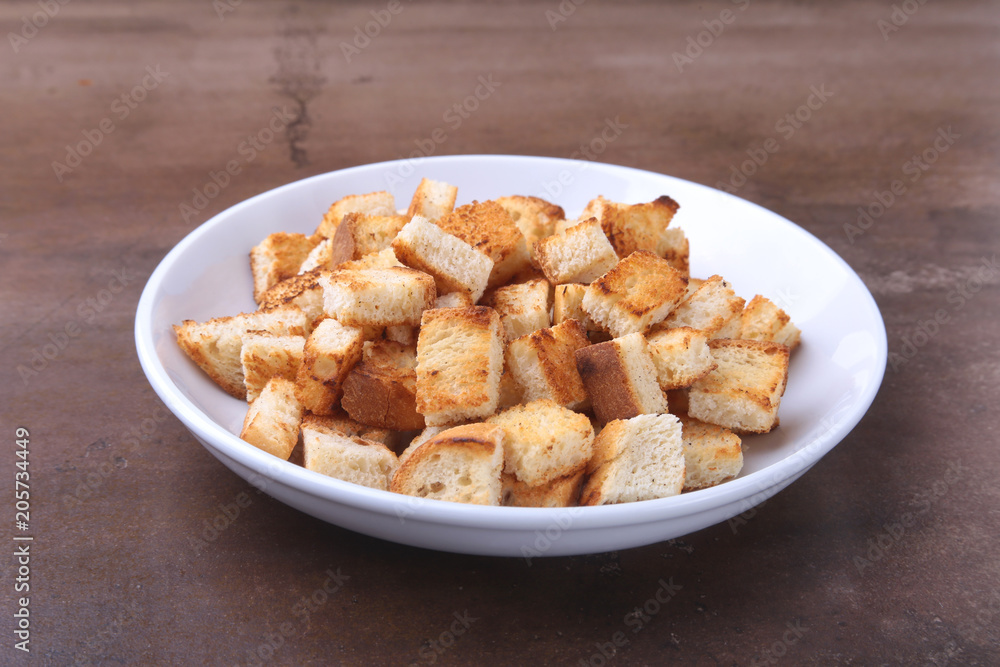 Delicious crispy croutons, crumbs of bread in white plate. ready for cooking. Delicious crispy croutons, crumbs of bread in white plate. ready for cooking.