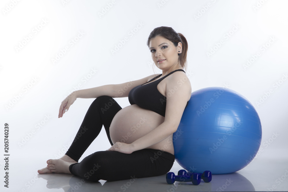 Pregnant woman is doing exercises with gymnastic ball on white background Pregnant woman is doing exercises with gymnastic ball on white background