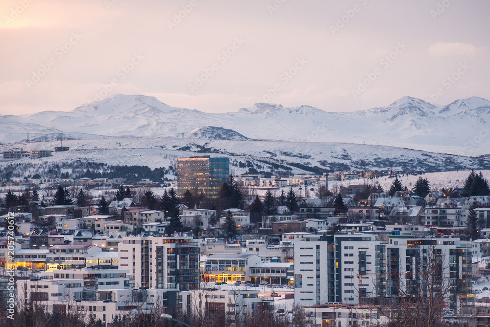 Modern urban development in Reykjavik, Iceland in front of snow covered mountains and fjords.